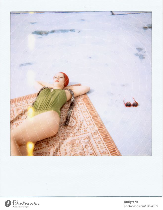 The girl with the beautiful red bathing cap and green swimsuit is sunbathing. A summer love. Girl Woman Swimwear Bathing cap Swimsuit Summer Skin youthful