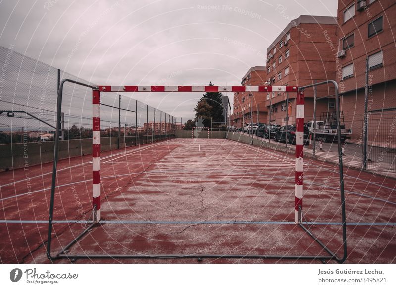 Worn and red soccer field abandoned background outdoors playing broken old park playground sports equipment rope web court street goal net bilbao Spain Bilbao