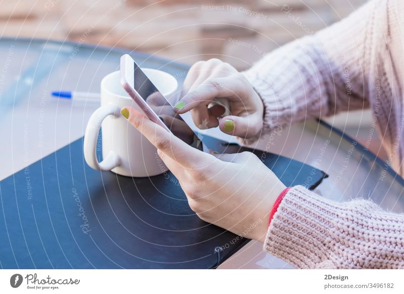 Macro shot of a girl hands, who reads messages on a smartphone. She touches the touch screen with her finger in order to flip the page. 1 holding using closeup