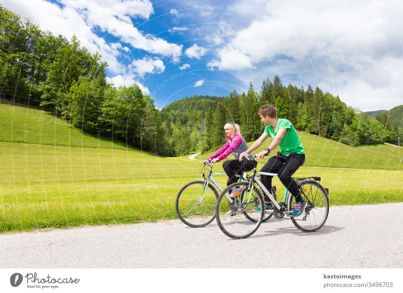 Young spoty active cople biking in nature. Active lifestyle. Activities and recreation outdoors. couple biker cycling cyclist people cycle summer track healthy