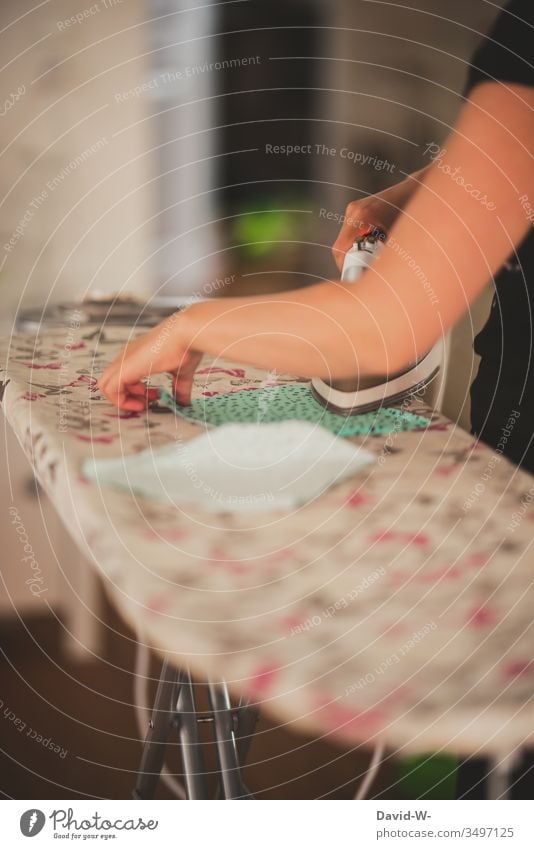 Woman ironing fabric with an iron on an ironing board Iron Electric iron Ironing board Cloth coronavirus Mask Mouth protection mask selfmade Housewife housework