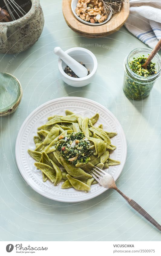 Top view of healthy lunch plate with green noodles or pasta and pesto on light background. Top view. Healthy vegetarian food top view cooking cuisine delicious