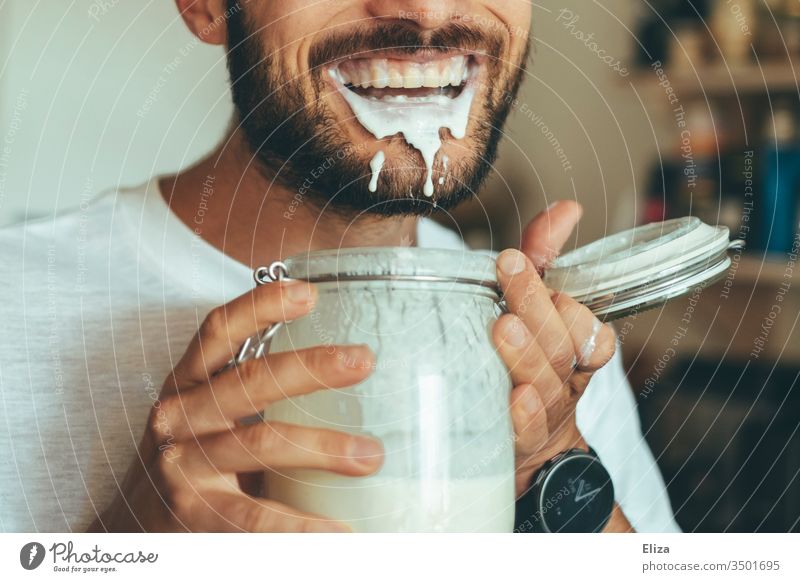 Man is happy about his homemade kefir full of protein and spills and drools around with it Protein high-protein low carb Joy Delicious feast Nutrition Slaver