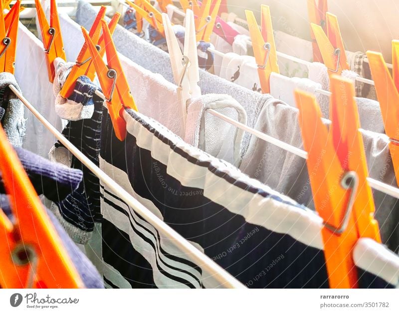 a group of orange clothes pegs on a drying rack to dry the laundry. Clothes hung out to dry inside a house. Housework and hygiene. clothespin clotheshorse dryer