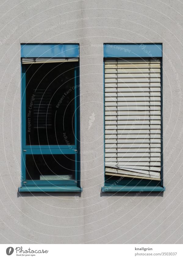 Two narrow windows with blue frames, one with lowered blinds, slightly crooked Window Venetian blinds Screening slanting obliquely Window frame 2 Pattern