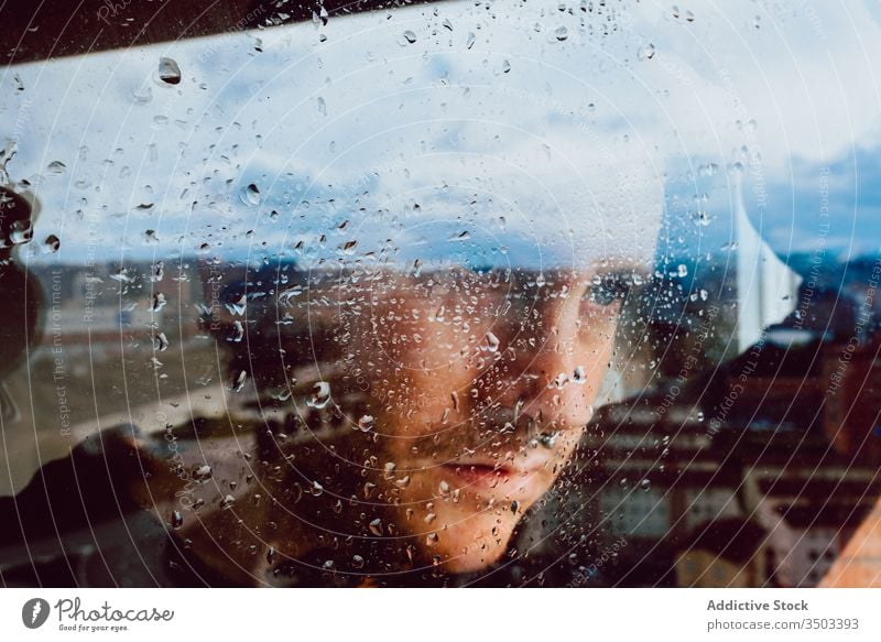 Depressed man looking through window sad depression isolation coronavirus home desperate lonely unhappy young male wet rain melancholy solitude stress frustrate