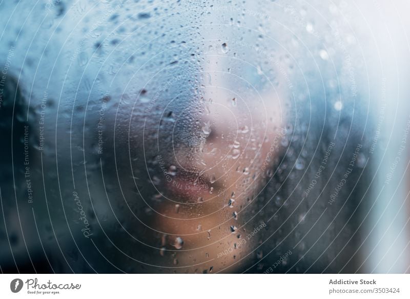 Unrecognizable person standing behind wet glass sad depression isolation melancholy solitude unhappy stress upset lonely rain coronavirus window home desperate