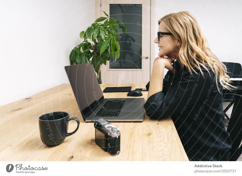 Woman working from her studio office at home woman desk computer business adult eyeglasses laptop caucasian browsing typing businesswoman internet home-office