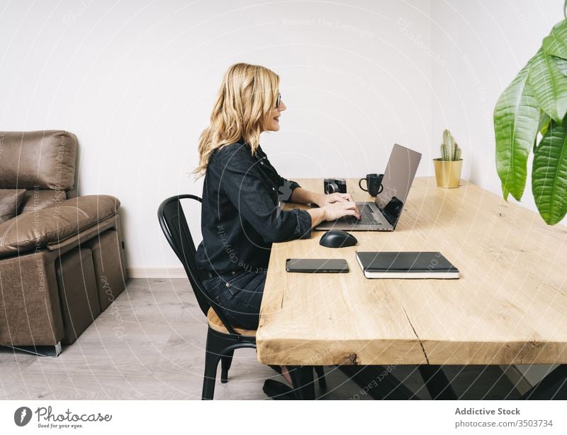 Woman working from her studio office at home woman desk computer business adult eyeglasses laptop caucasian browsing typing businesswoman internet home-office