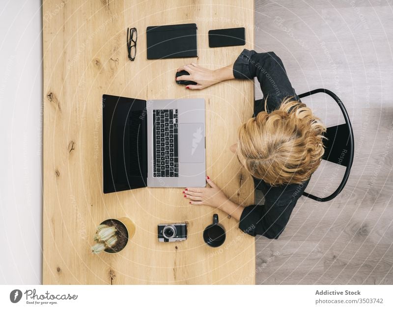 Woman working from her studio office at home. computer technology business desk workplace woman coffee laptop view internet using education cup phone wooden mug