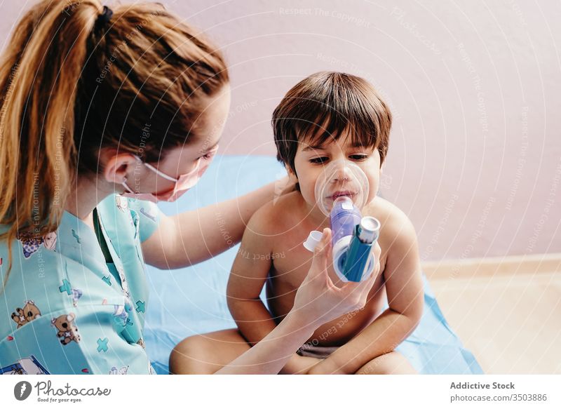 Sick boy getting inhalation treatment in clinic child inhale respiration sick medicine medical respiratory doctor mask little woman hospital health care patient