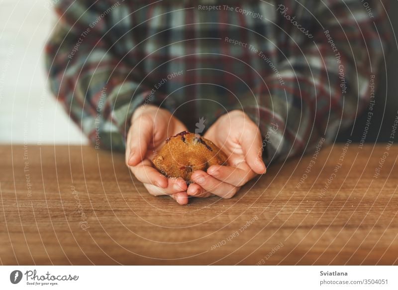 Over the wooden table, children's hands are holding delicious cupcakes food bakery bread dessert pastry snack sugar sweet background baked berry breakfast brown