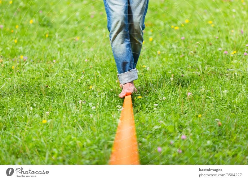 Slack line in the city park. slack line slackline activity sport balance tightrope young person fitness back nature concentration male walking outdoors skill