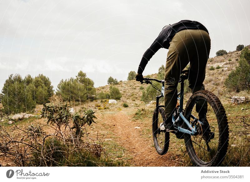 Cyclist riding bike on rocky path in forest man bicycle ride tree travel cyclist helmet male trip journey activity recreation route vehicle transport lifestyle