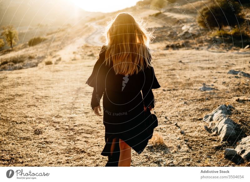 Stylish woman standing on rock in countryside style stone sunset hat walk outfit slime female model black trendy nature boulder sundown evening twilight dusk