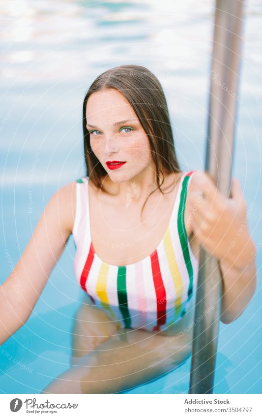 close-up of a brunette girl with long hair on a stairs in the pool water blue leisure teenager young female woman person summer fun people beautiful smile swim