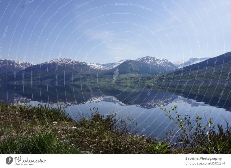 Reflection of nature in the snowy mountains of Norway on a sunny day Norwegian beauty. Landscape reflection Reflection in the water Mountain Europe