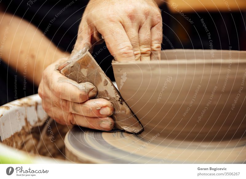 Close up detail view at an artist makes clay pottery on a spin wheel shape finger hand craft man traditional work wet handmade bowl creativity dirty creative