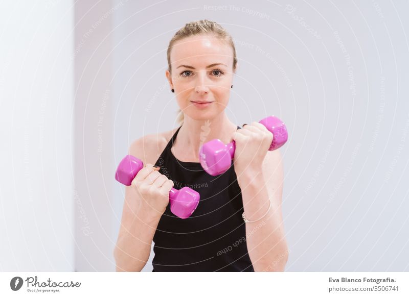 group of women practicing sport at the gym with dumbbells. Healthy lifestyle friends healthy indoors fitness training heavy care push press-ups girl male