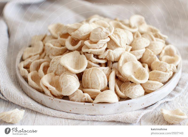 Fresh raw  italian pasta orecchiette apulia fresh dry traditional ingredient close up plate diet flour handmade homemade mediterranean organic regional salento