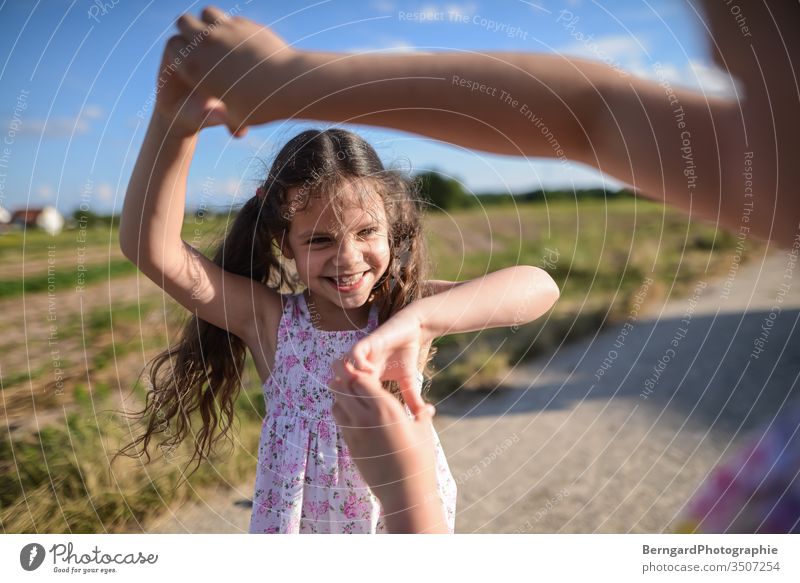 Two sisters play games Sister Girl Brothers and sisters Exterior shot Smiley happy buzzer playtime Sun Field light