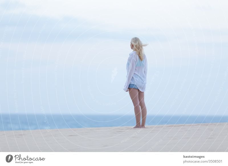 Woman on sandy beach in white shirt at dusk. summer woman sensual healthy girl sexy sea ocean body beauty lady holiday water travel vacation coast tropical