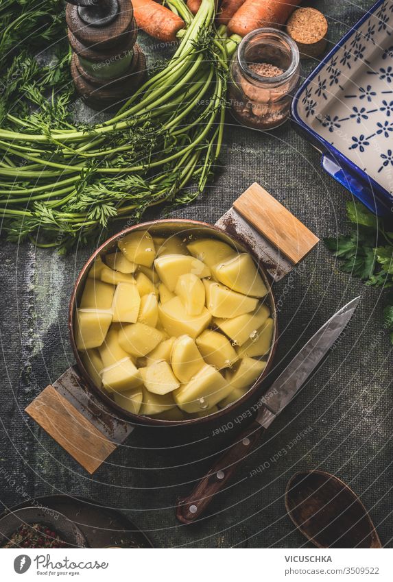 Raw potatoes in copper cooking pot in water on rustic kitchen table background. Top view. Potato cooking preparation. raw top view boil uncooked natural