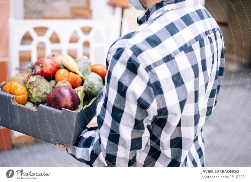 Volunteer guy with flu mask delivering a box of groceries during corona virus lockdown. Volunteer,medical emergency,covid19 concept aid assistance assistant