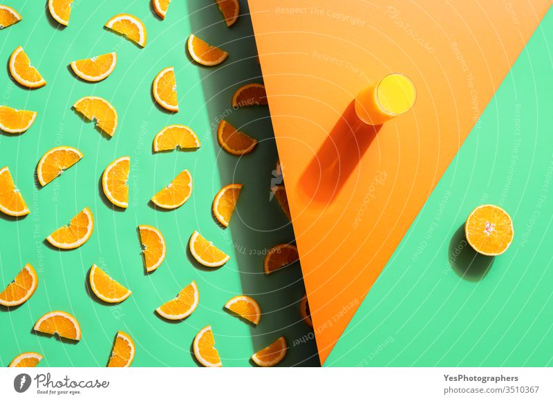 Orange juice glass and orange slices on duotone background. Summer drink beverage bicolor citrus fruits cocktail colorful concentrate detox beverage extract