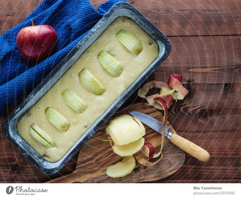 Stuffed mould for baking an apple cake on a dark wooden base. Copy space. Baking concept. Sponge cake raw sweet dessert cake tin pastry food unbaked top view