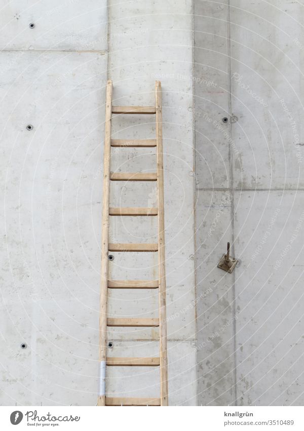 On a construction site a wooden ladder leans against a concrete wall Ladder Concrete wall Construction site Wooden ladder rung ladder Wall (building) Build job