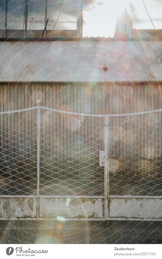 Garage door with fence in light grey with numerous Lens Flares Fence Gray Gloomy Sun Back-light lens flares light spots Lens Reflection Highway ramp (entrance)