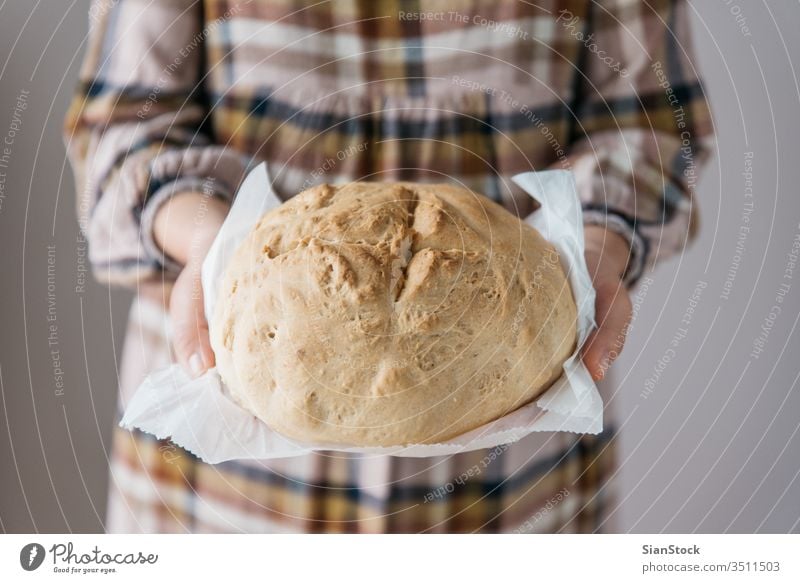 Woman holding tasty fresh handmade bread, in her home,  close up woman home-made girl chef cuisine eating organic food baker homemade bakery kitchen loaf rustic