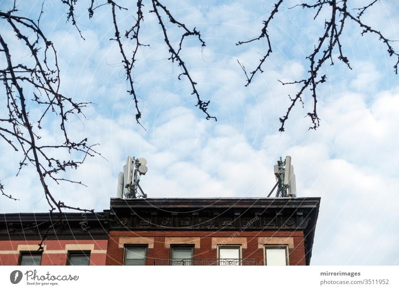 Spring trees, New York buildings with cell phone towers on their roof on a sunny, cold day Architecture Sky no people Building exterior City Repetition Tower