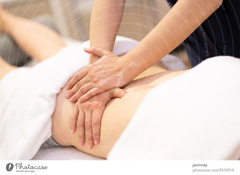 Young woman receiving a back massage in a physiotherapy center spa body treatment salon care young female relaxation skin health healthy wellness lying hands