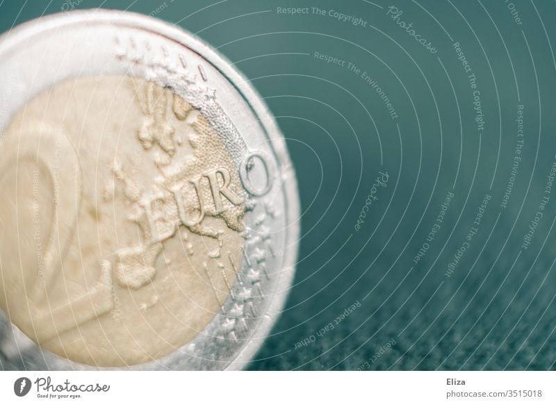 Close-up of a two euro coin against a turquoise background; money, finances Money Macro (Extreme close-up) Euro Bright Financial Statements Save