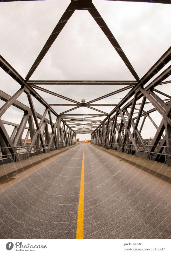 trussed bridge with roadway below Baaken Bridge Street Traffic infrastructure Historic Lane markings Construction Vanishing point Architecture Iron Symmetry