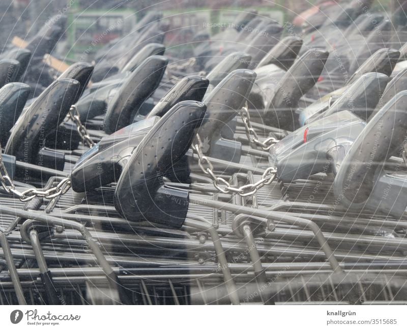 Black handles of shopping trolleys that are connected to each other Shopping Trolley ally at the same time Chain link Metal Reflection Colour photo