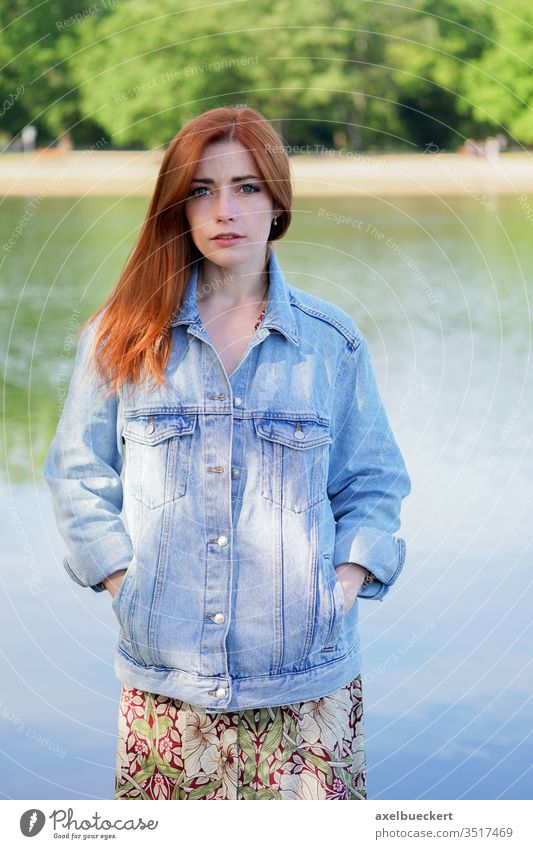 authentic young woman wearing denim jacket over summer dress standing by lake girl jeans adult person people women red hair redhead caucasian pretty female