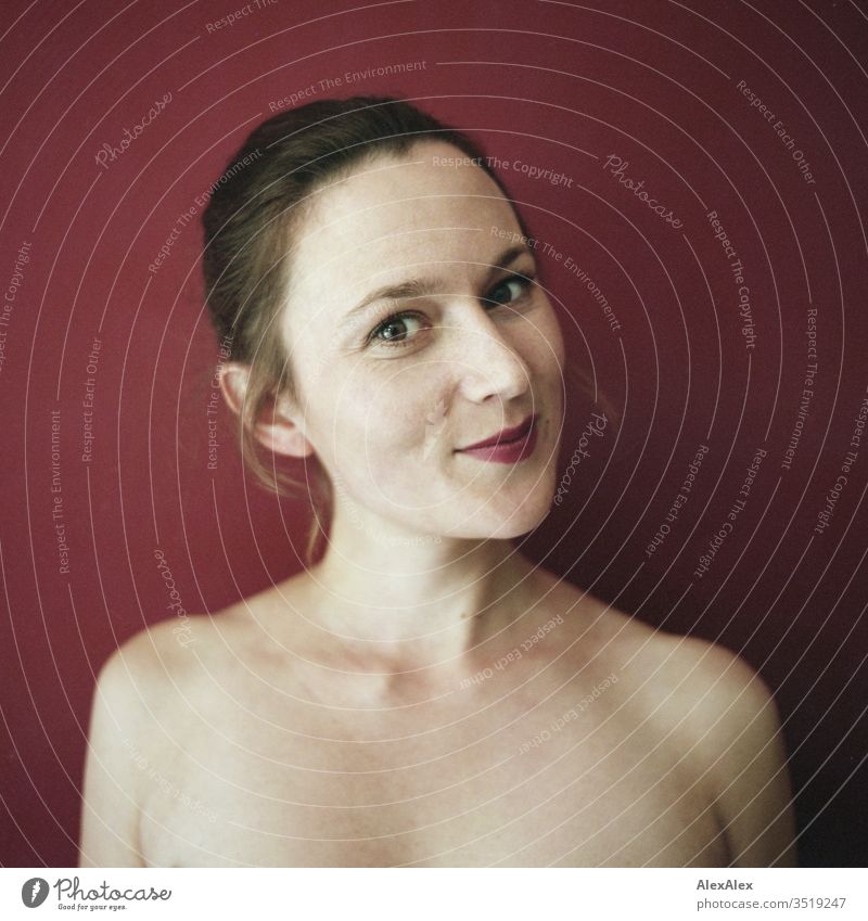 Analogue portrait of a young woman in front of a red wall Delicate Shadow Light picture-like Athletic Feminine empathy Emotions emotionally Central perspective