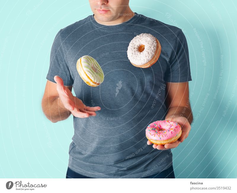 Juggler man juggles donuts on blue background juggler doughnuts delivery healthy unhealthy diet sugar juggling concept game play cafe sprinkles concentration