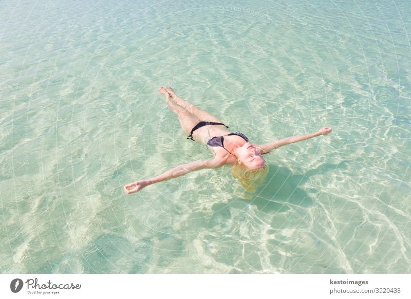 Caucasian lady floating in turquoise sea. woman beach water swim blue lagoon travel vacation beauty summer coast adult bay attractive beautiful bikini body calm