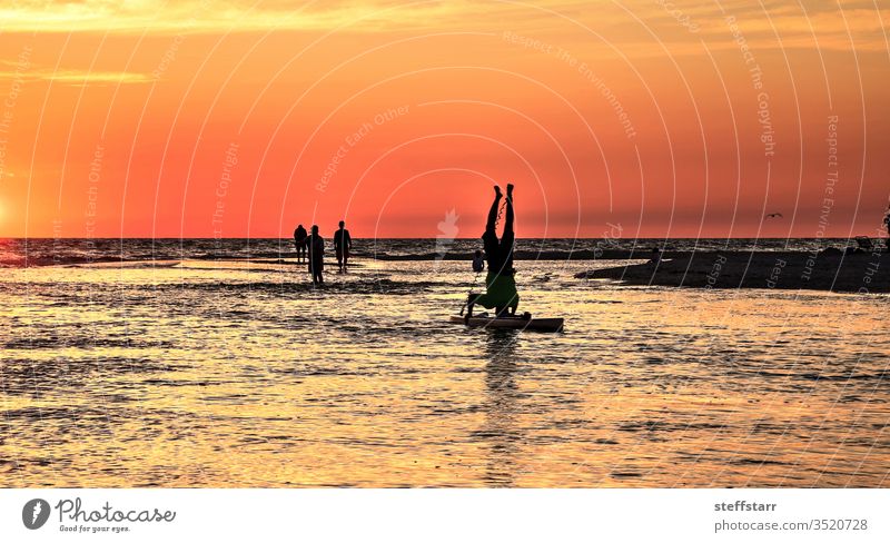 Upside down handstand on a Paddleboard done at sunset headstand dusk ocean yoga Laguna Beach surfer California Coast coastline coastal paddleboarder landscape