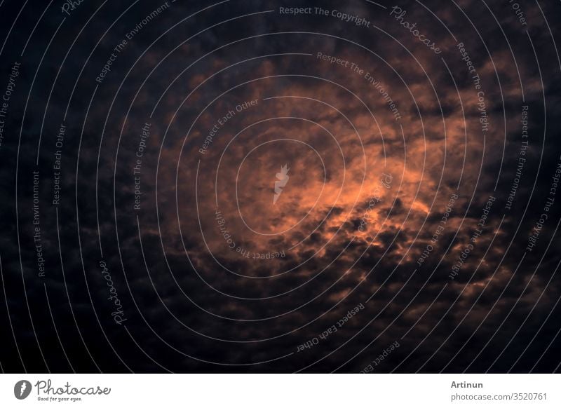 Red light of sun in dark cloudy sunset sky. Dramatic sky with beautiful pattern of fluffy clouds. Mental power or psychic power background. Power of nature. Exotic cloudscape. Climate change concept.