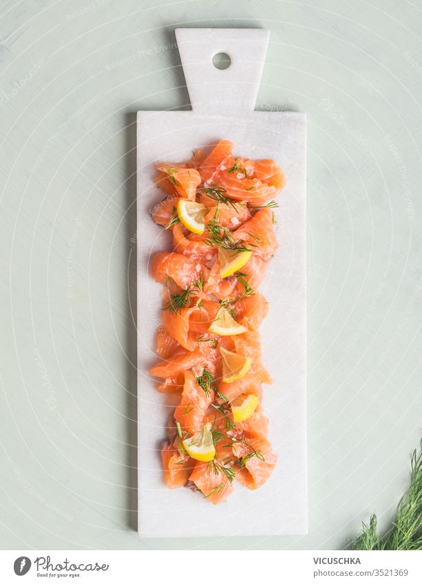 Slices of homemade smoked salmon fillet with dill and lemon . Top view. Healthy food slices served marble cutting board light background top view healthy