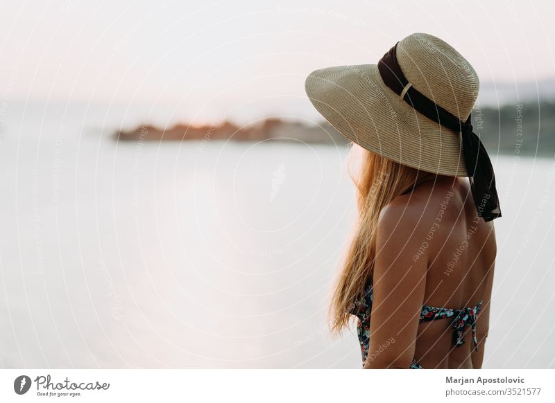 Young woman enjoying sunset by the sea adventure beautiful beauty carefree cliff coast coastal coastline evening female freedom girl hat holiday horizon