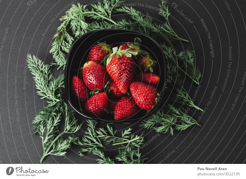 Ecological strawberries in black plate on black background. Top view strawberry herbs delicious ecological food fresh fruit healthy ingredient above top view