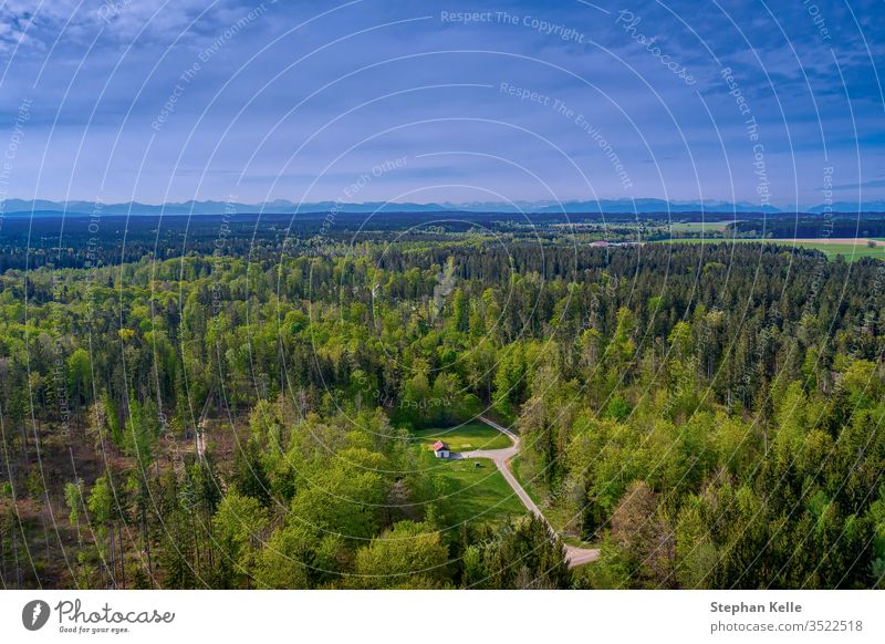 A lonely idyllic house in the middle of a green forest in spring, bavaria, germany. background mountain summer nature outdoor panorama panoramic landscape hill