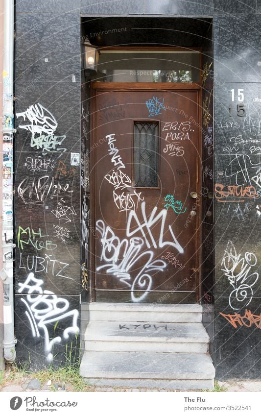 Front door with graffiti Graffiti front door Entrance Stairs House front smudged Gray Black Brown wood Old Granite Weed Tags White Daub Decline Deserted