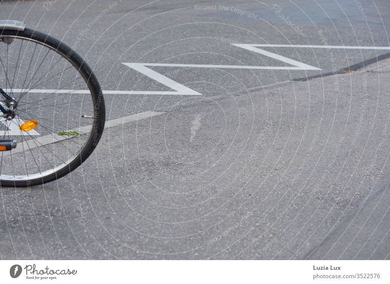 Bicycle parked on a barrier: perfect geometry of spokes, round, zigzag and even a little green. Wheel spoke wheel Street restricted area geometric Geometry